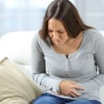 "امرأة تشعر بمغص بداية الحمل، يوضح الأسباب الطبيعية للألم وكيفية تخفيفه بأمان."