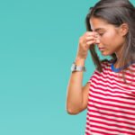 "شخص يشعر بالتعب طوال اليوم بدون سبب واضح، يوضح مشاكل النوم، نقص المغذيات، والتوتر كمسببات للتعب المزمن."